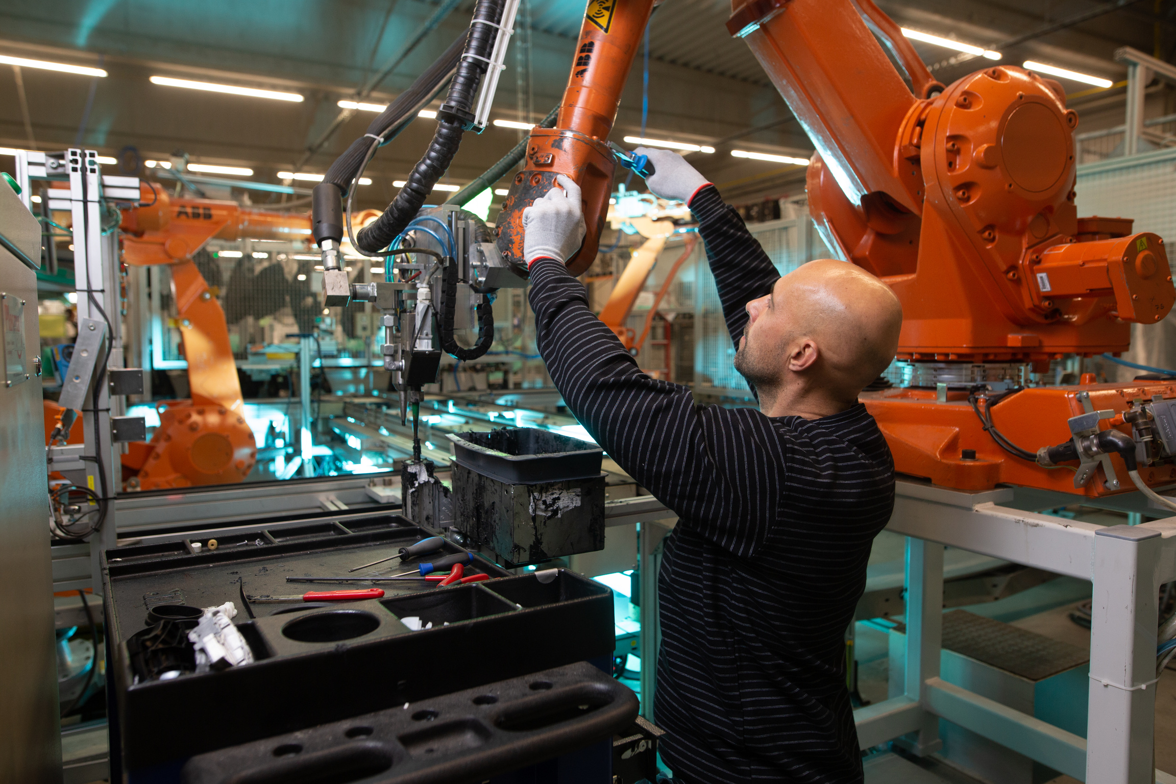 Engineer Optimizing Production by Robotic Arm in Automotive Smar